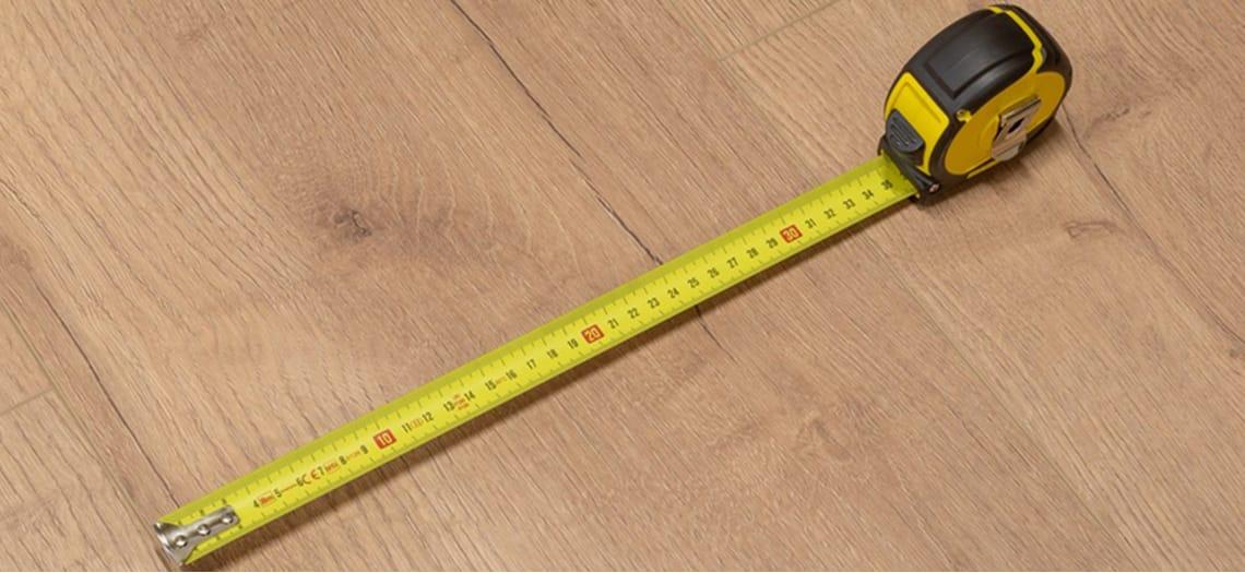 Rolmaat op een houten vloer tijdens het opmeten