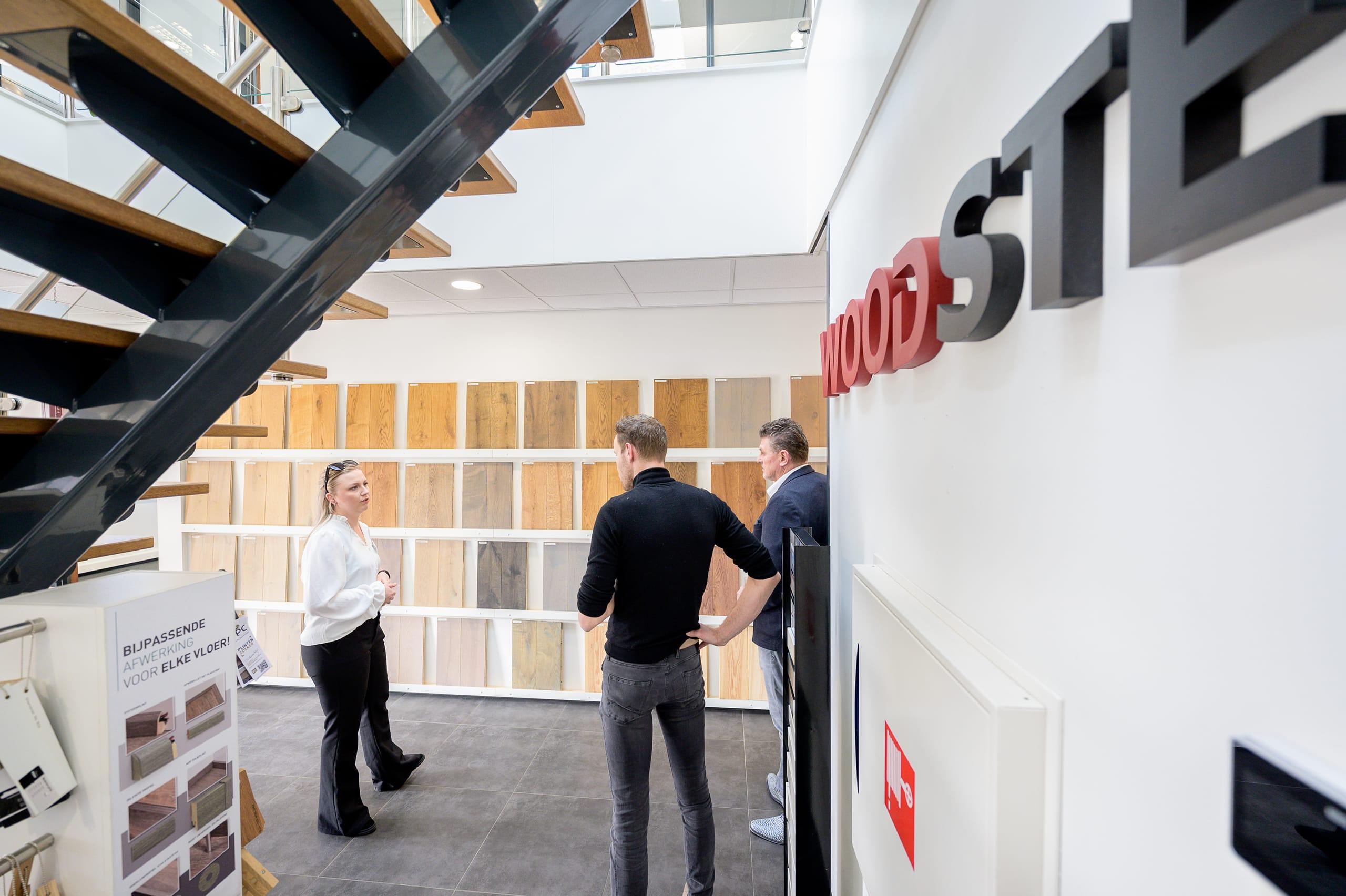 Adviseur van Woodstep bij de kleurenwand in de showroom