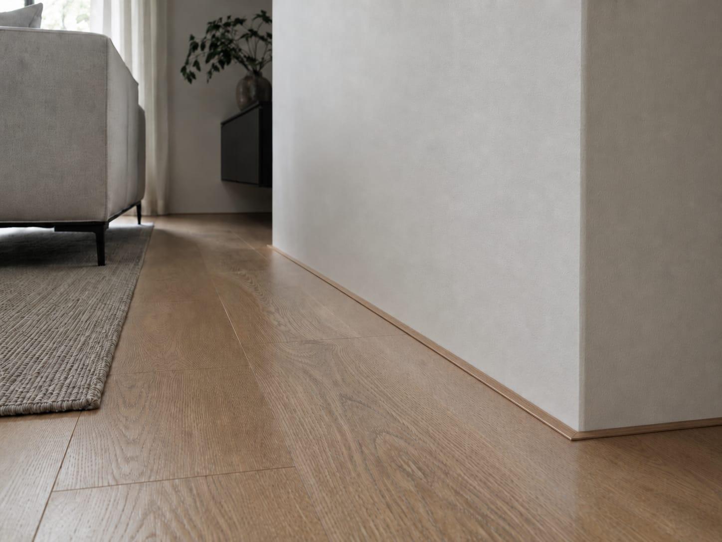 Platte afwerklijst langs een houten vloer