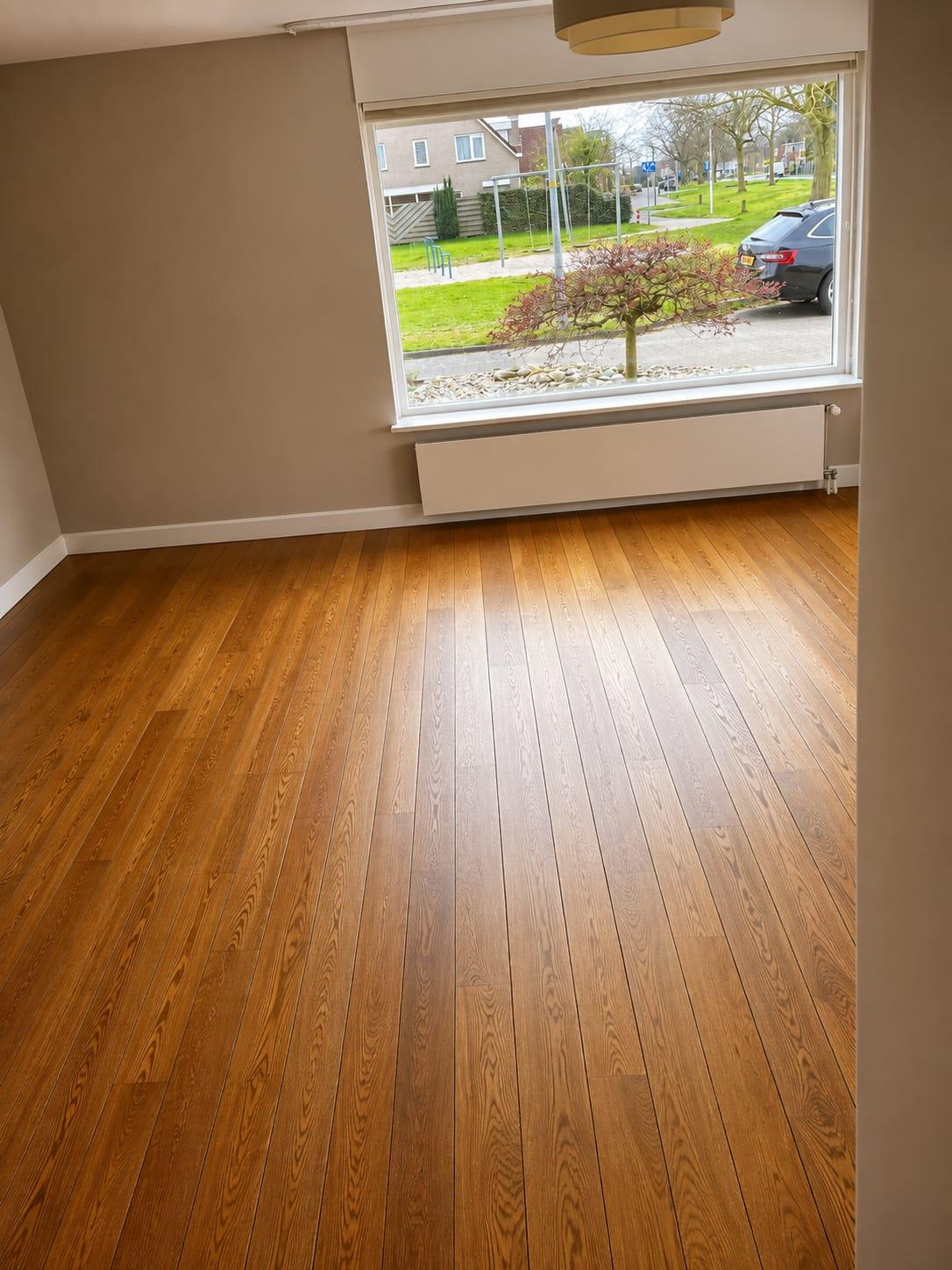 Warme eiken strokenvloer in een kamer met erker
