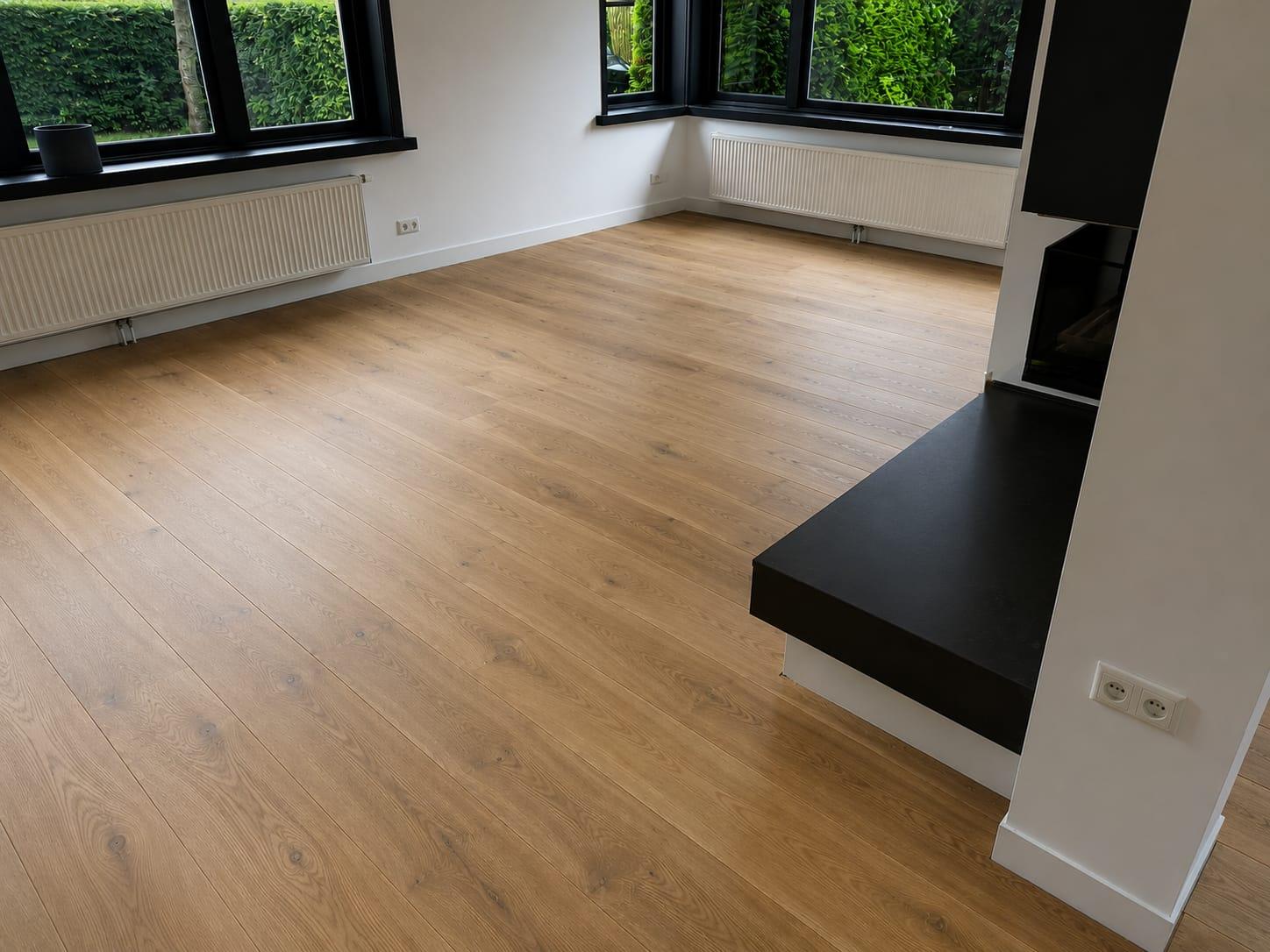 Eiken strokenvloer in een woonkamer met zwarte kozijnen