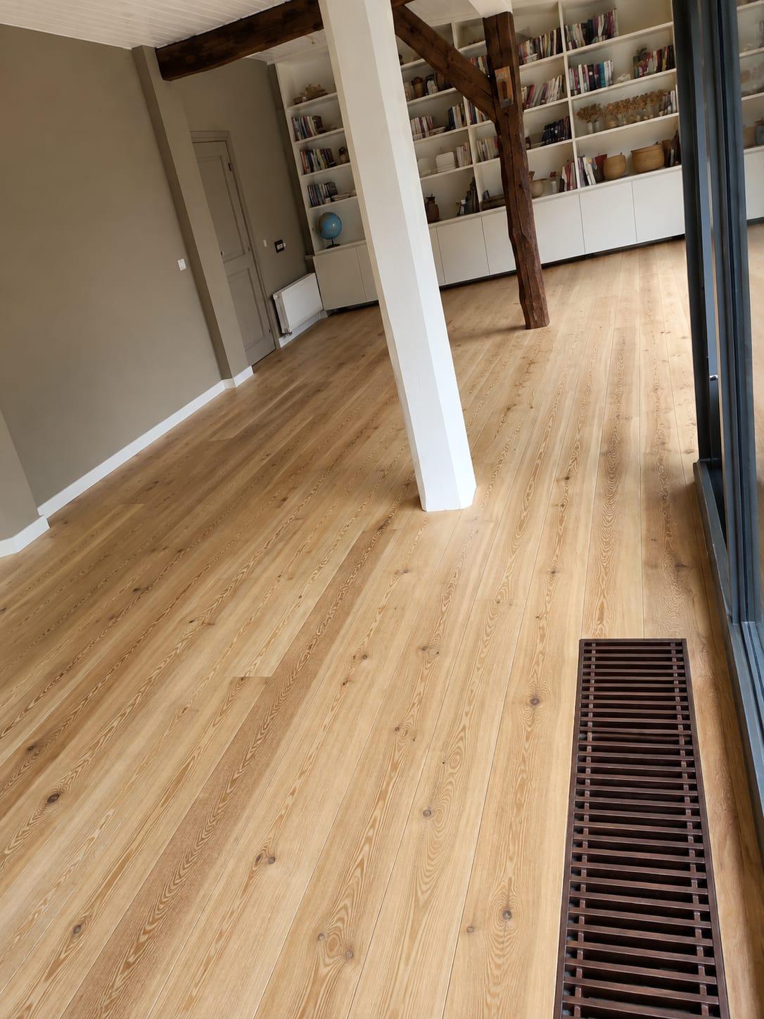 Lichte grenen plankenvloer in een kamer met boekenkasten